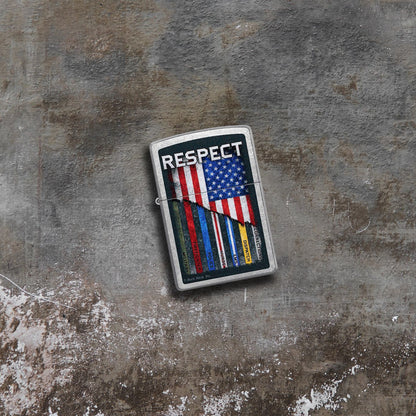 Lifestyle image of Zippo Buck Wear™ Respect Design Street Chrome Windproof Lighter lying on concrete while showing the front of the lighter. 

