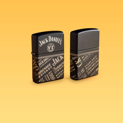 Lifestyle image of two Zippo Jack Daniel's® Every Drop Design Regular Media Chrome Black Matte Windproof Lighters standing with a pale yellow background.