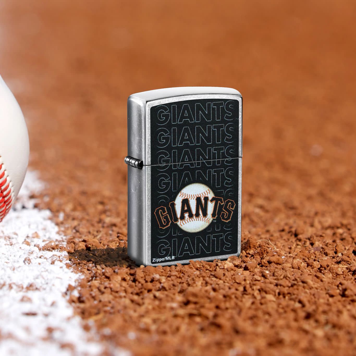 Lifestyle image of Zippo MLB® San Francisco Giants Street Chrome Windproof Lighter standing in the dirt on a baseball field.