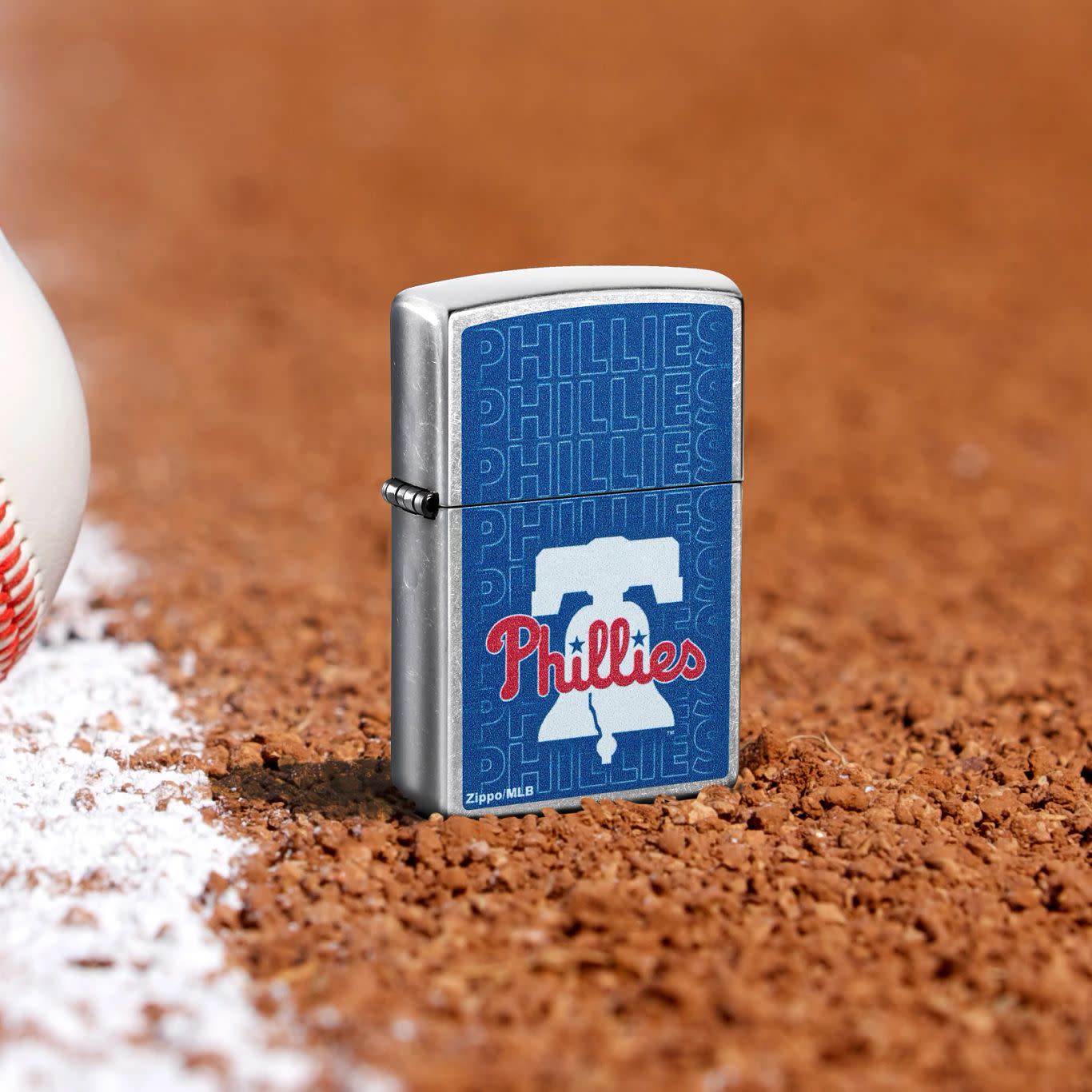 Lifestyle image of Zippo MLB® Philadelphia Phillies Street Chrome Windproof Lighter standing in the dirt on a baseball field.