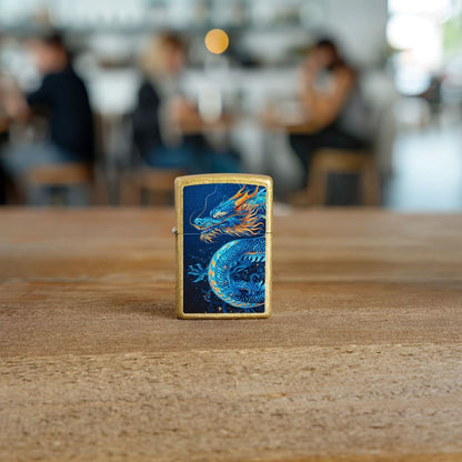 Lifestyle image of Zippo Sea Dragon Design Street Brass Windproof Lighter standing on the floor showing the front of the lighter with an out of focus restaurant as the background. 

