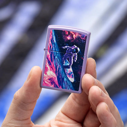 Lifestyle image of Zippo Star Surfer Design Smoky Lavender Windproof Lighter being held in hand while showing the front of the lighter with a purple and black graffiti background. 

