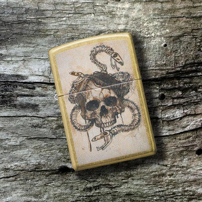 Lifestyle image of Zippo Skull and Snake bones Design Street Brass Windproof Lighter lying on a plank of old weathered wood, showing the front of the lighter. 

