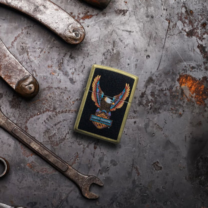 Lifestyle image of Zippo Harley-Davidson® Eagle Street Brass Windproof Lighter laying on a rusted and dented piece of metal with tools surrounding it.