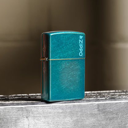 Lifestyle image of Zippo Classic Candy Teal Zippo Logo Windproof Lighter standing at a 3/4 angle on a steel beam showing the front and hinge side of the lighter. 

