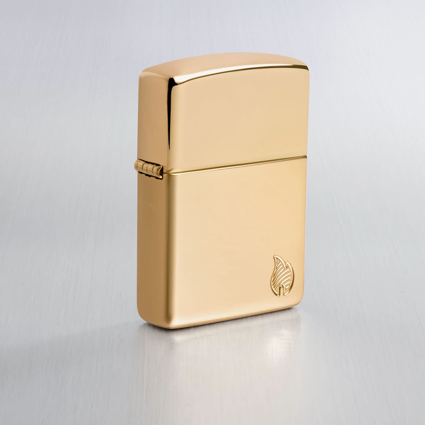 Lifestyle image of Zippo Armor® Series Flame High Polish Brass Windproof Lighter on a light gray background.