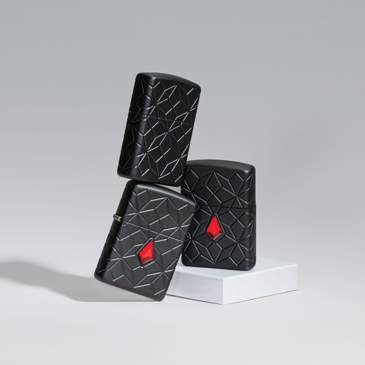 Lifestyle image of Zippo Crystal Design Armor® Black Matte Windproof Lighters standing on top of each other, showing all angles of the lighter.