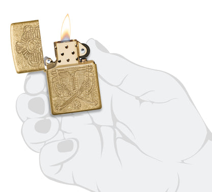 Zippo Mummy Design Armor® Tumbled Brass Windproof Lighter lit in hand.