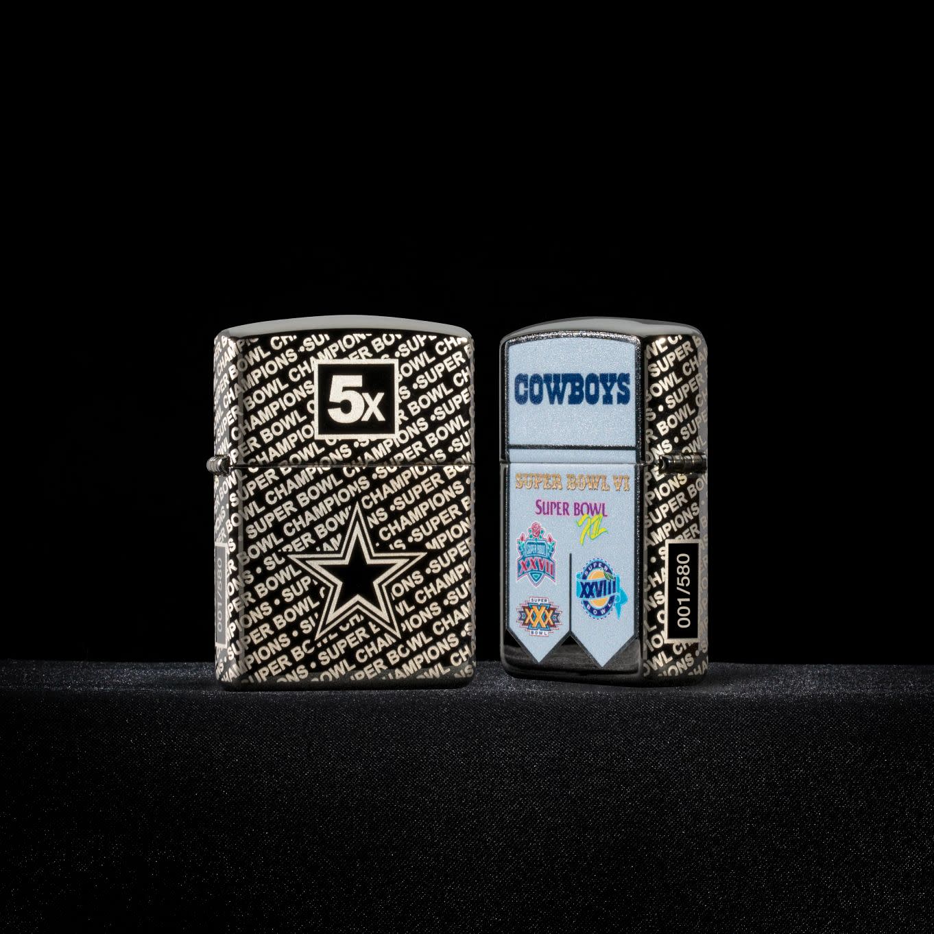 Lifestyle image of two Zippo NFL Dallas Cowboys Super Bowl Commemorative Armor Black Ice Windproof Lighters with a black background.