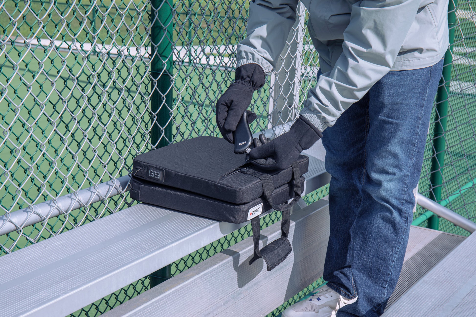 Lifestyle image of Zippo Heated Seat - Double with a man plugging in the HeatBank® 9s (included).