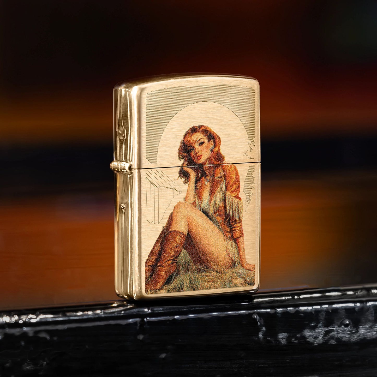 Lifestyle image of Zippo Western Pinup Design Brushed Brass Windproof Lighter standing on a black windowsill showing the front and hinge side of the lighter. 

