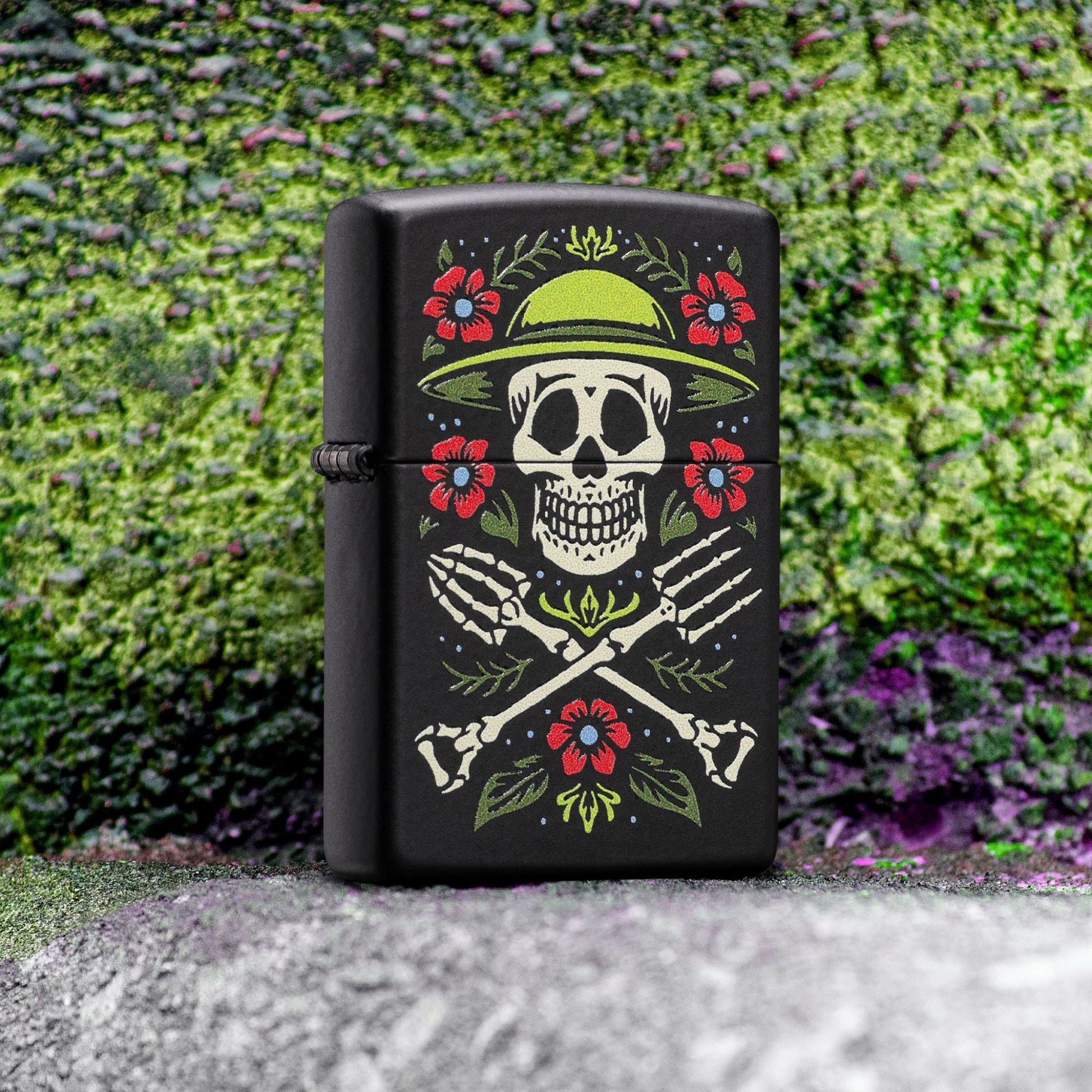 Lifestyle image of Zippo Garden for Life Design Black Matte Windproof Lighter standing on a concrete step next to graffiti wall art showing the front of the lighter.