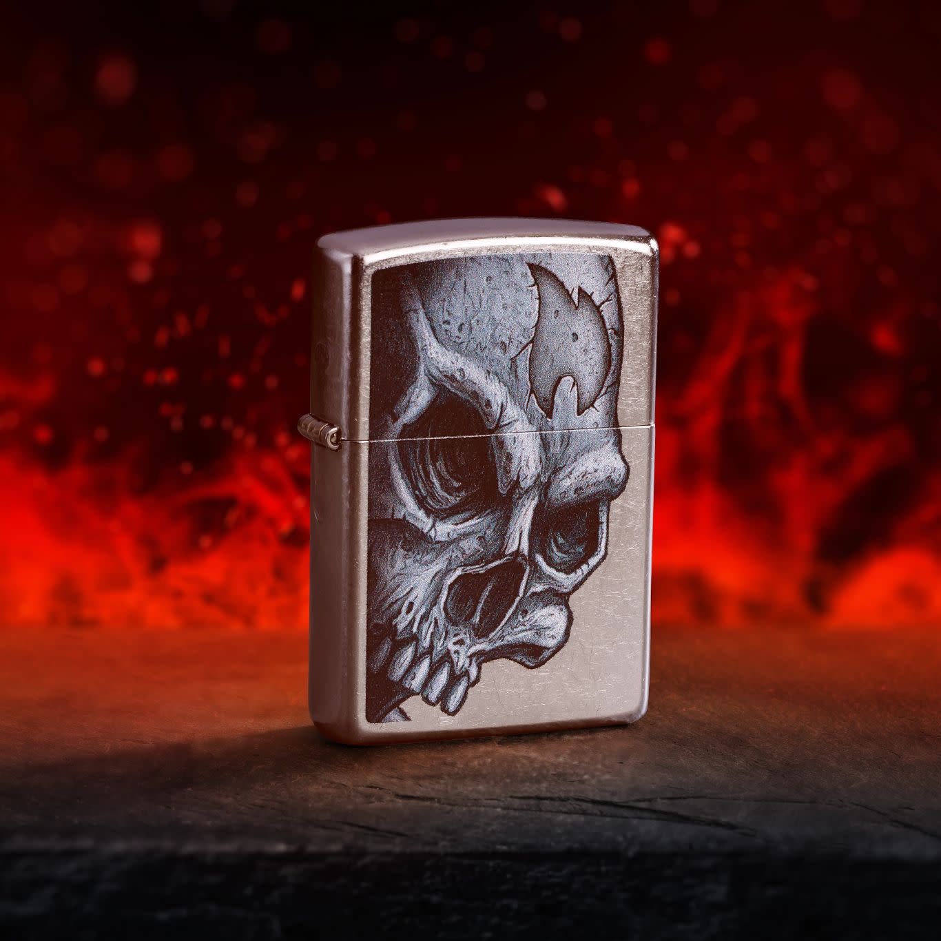 Lifestyle image of Zippo Skull and Flame Design Street Chrome Windproof Lighter standing on a dark surface with red flames in the background.