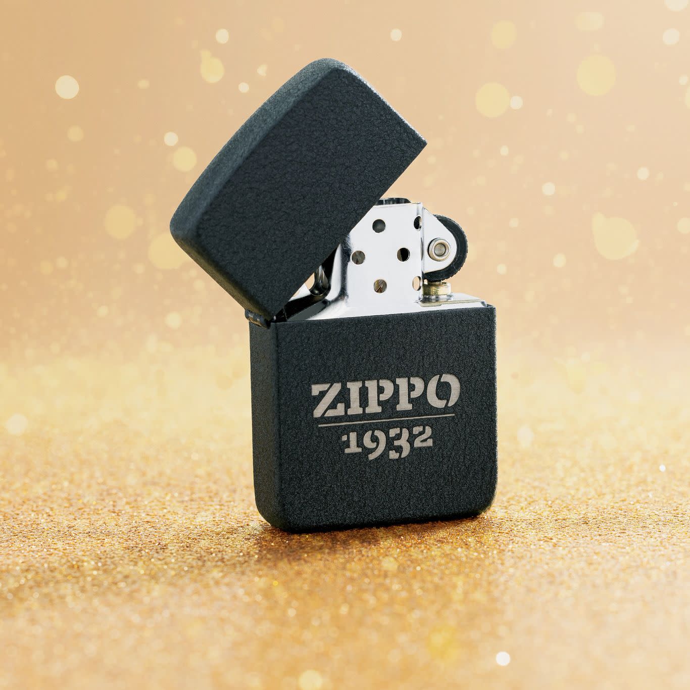 Lifestyle image of Zippo Design 1941 Replica Black Crackle® Windproof Lighter standing on a golden surface with glittery flakes surrounding it.