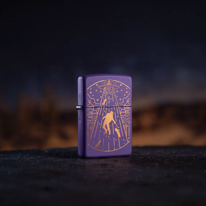 Lifestyle image of Zippo Beam Me Up Design Purple Matte Windproof Lighter standing on a black surface showing the front and hinge side of the lighter with an out of focus dark background. 

