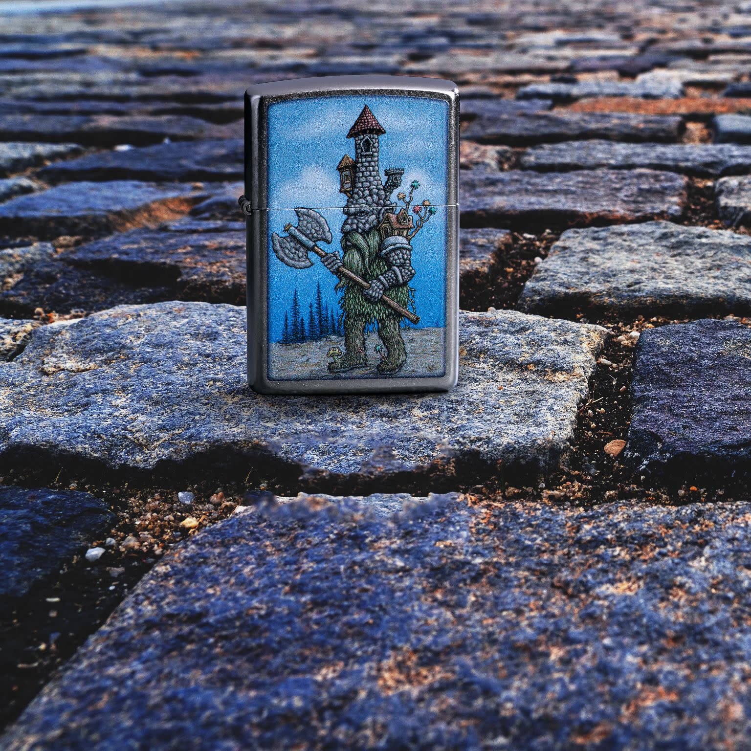 Lifestyle image of Zippo Castle Troll Design Street Chrome Windproof Lighter standing on a rock path.