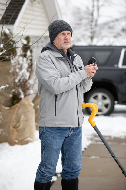 Man shoveling snow with the Black 12-Hour Refillable Hand Warmer in his hand