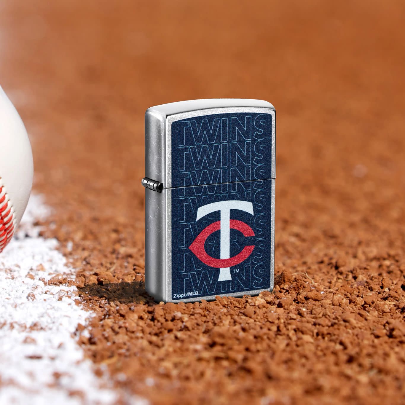 Lifestyle image of Zippo MLB® Minnesota Twins Street Chrome Windproof Lighter standing in the dirt on a baseball field.