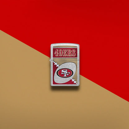 Lifestyle image of Zippo NFL San Francisco 49ers Street Chrome Windproof Lighter set on a gold and scarlet background.