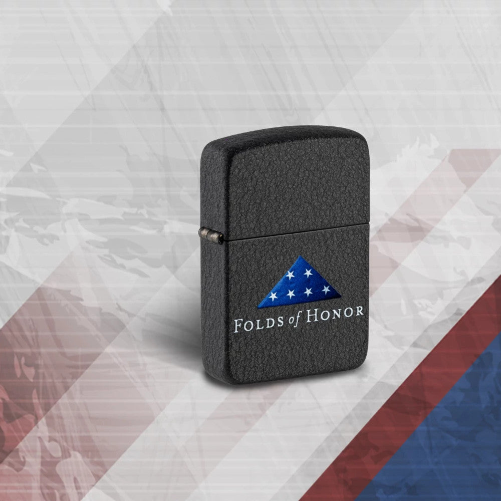 Lifestyle image of Zippo Folds of Honor Black Crackle Windproof Lighter standing on a red, white and blue striped background.