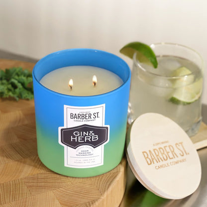 Lifestyle image of Zippo Barber Street Gin Herb Odor Masking Candle on a counter top, lit, and standing with a drink.