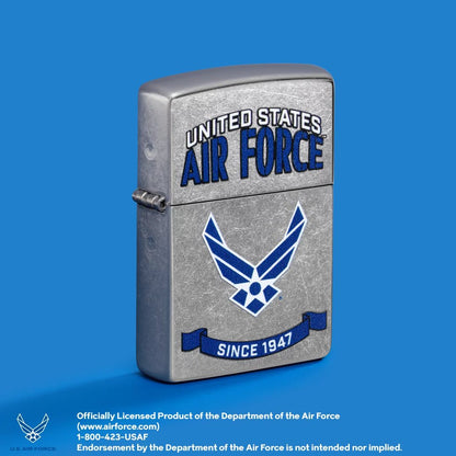 Lifestyle image of Zippo U.S. Air Force™ Banner Design Street Chrome Windproof Lighter standing at a 3/4 angle showing the front and hinge side of the lighter with a light blue background. 

