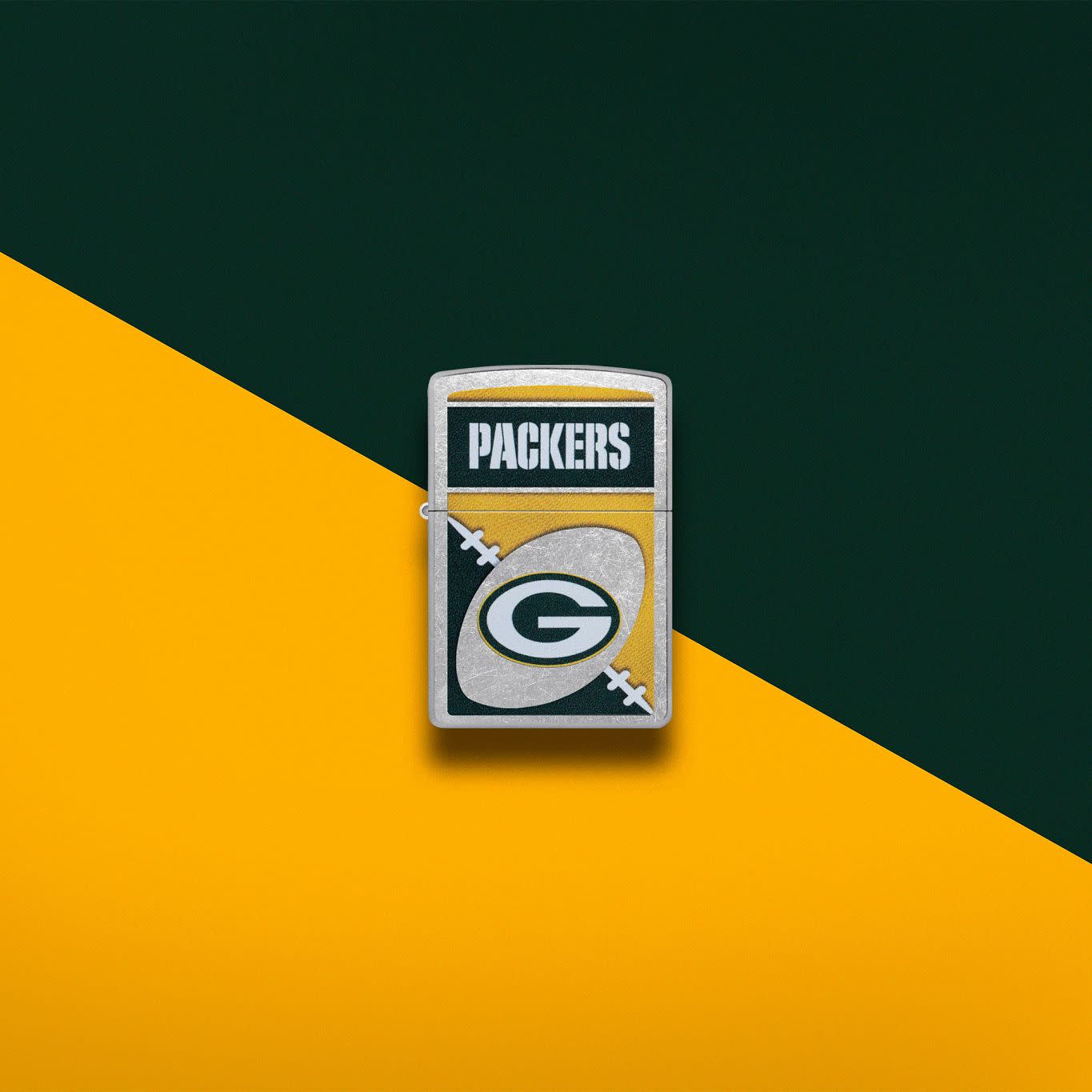 Lifestyle image of Zippo NFL Green Bay Packers Street Chrome Windproof Lighter set on a yellow and green background.