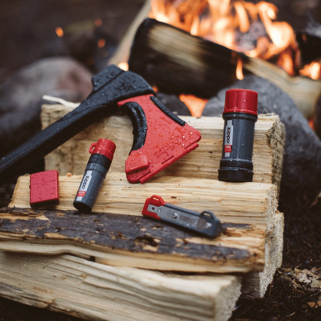 AxeSaw laying on chopped wood with other Zippo products