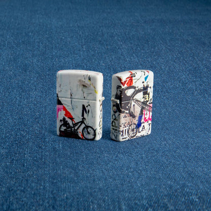 Lifestyle image of two Zippo Pop Art Design 540 Color Windproof Lighter, one showing the back and the other showing the front of the design. Lighters are standing in a blue background.