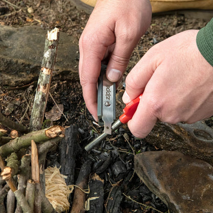 Lifestyle image of man using the mag strike ferrocerium rod to start a fire