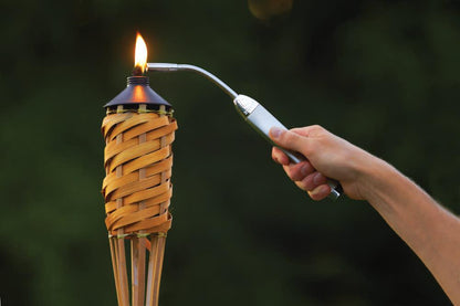 Lifestyle image of Chrome Flex Neck Utility Lighter lighting a tiki torch