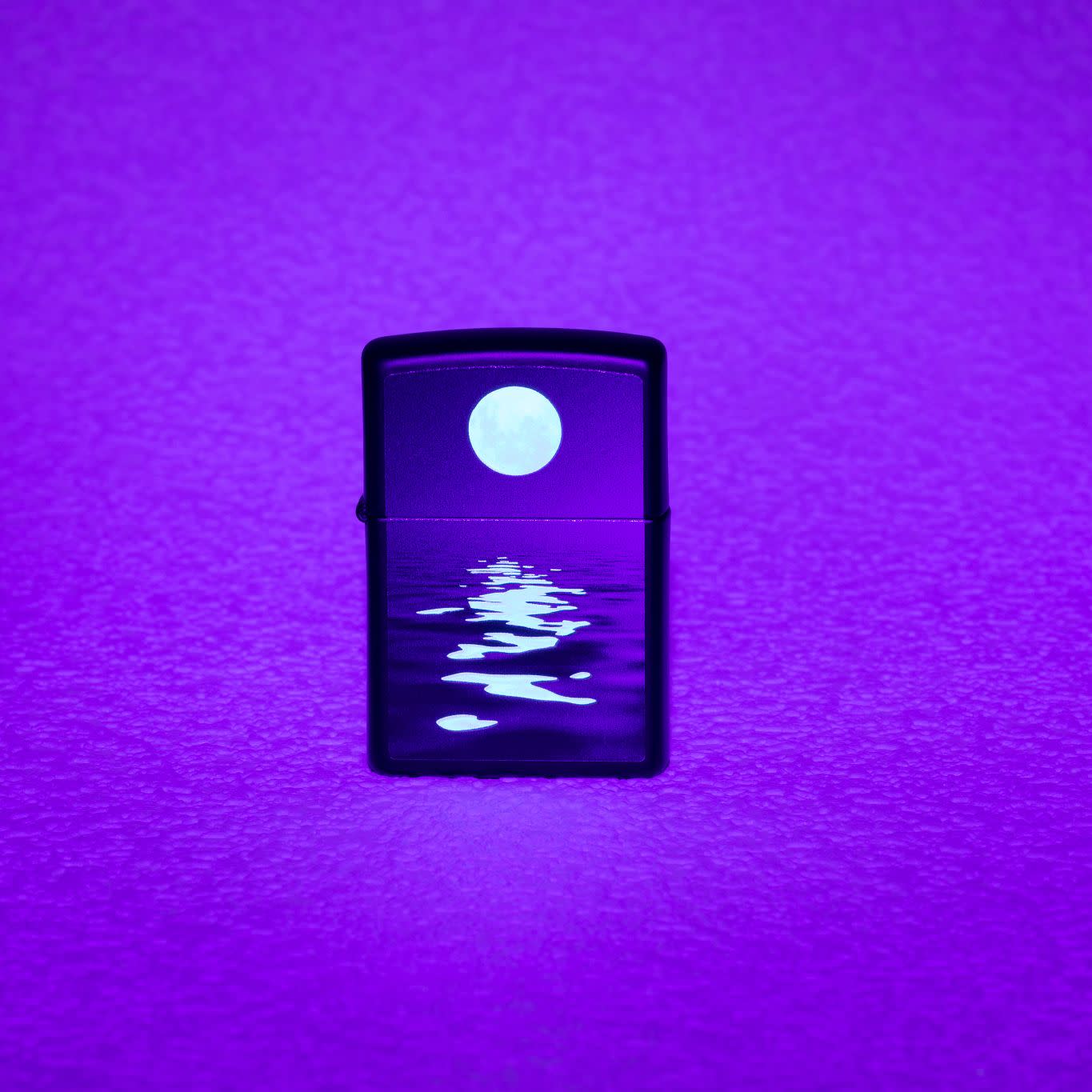 Lifestyle image of Full Moon Design Black Light Black Matte Windproof Lighter showing the blacklight design.