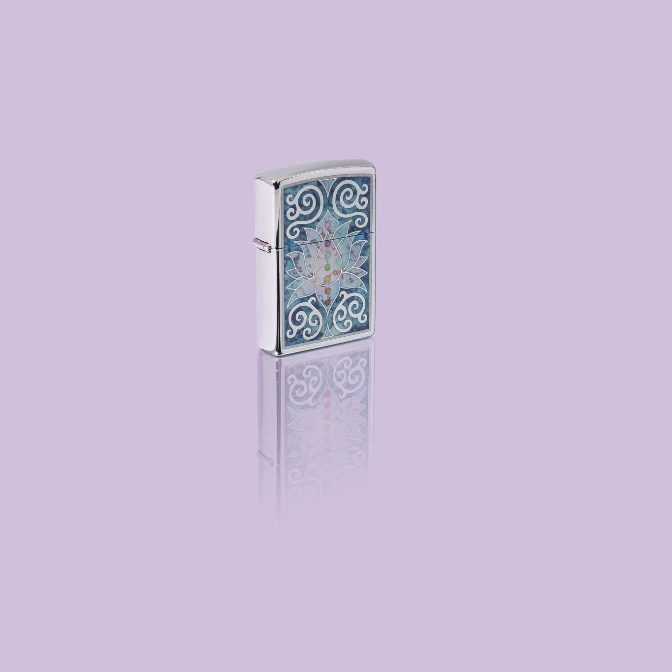 Glamour shot of Zippo Fusion Lotus Flower Design High Polish Chrome Windproof Lighter standing in a purple scene.