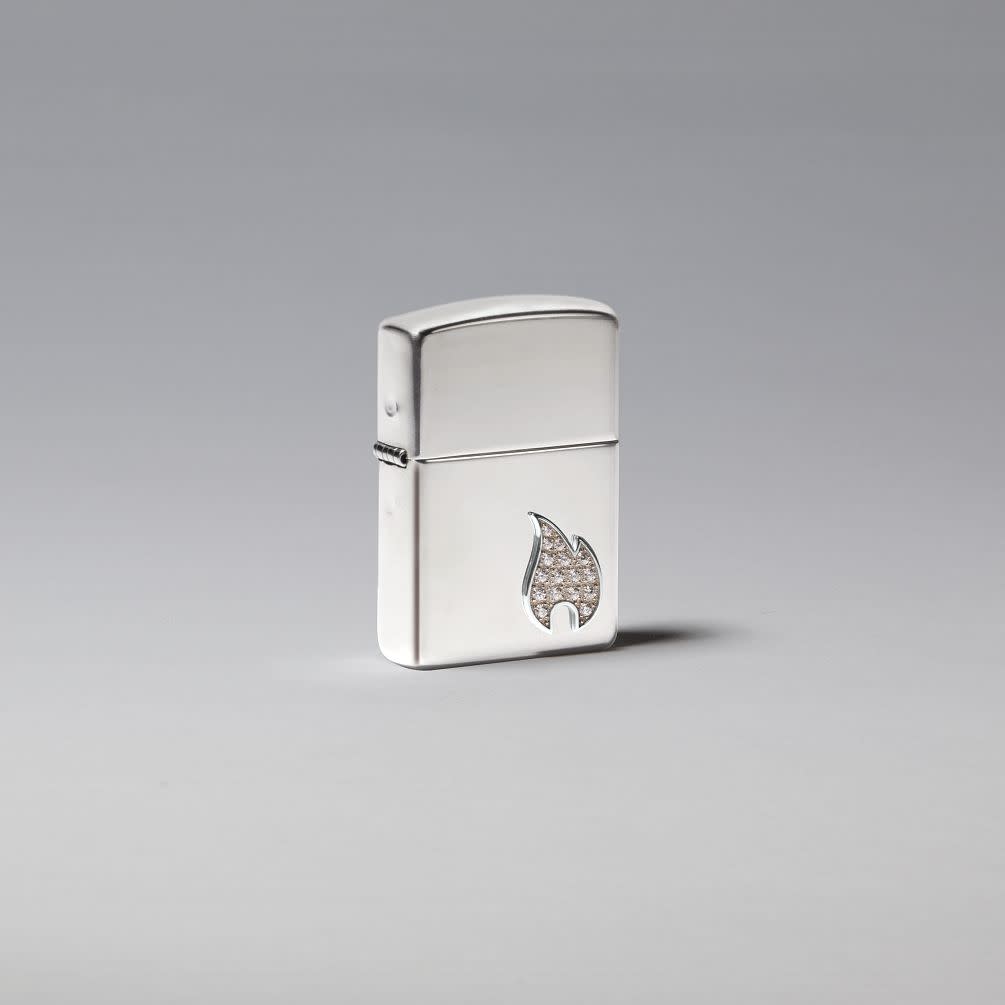 Lifestyle image of ArmorÂ® Sterling Silver Flame Emblem Windproof Lighter standing in a silver scene.