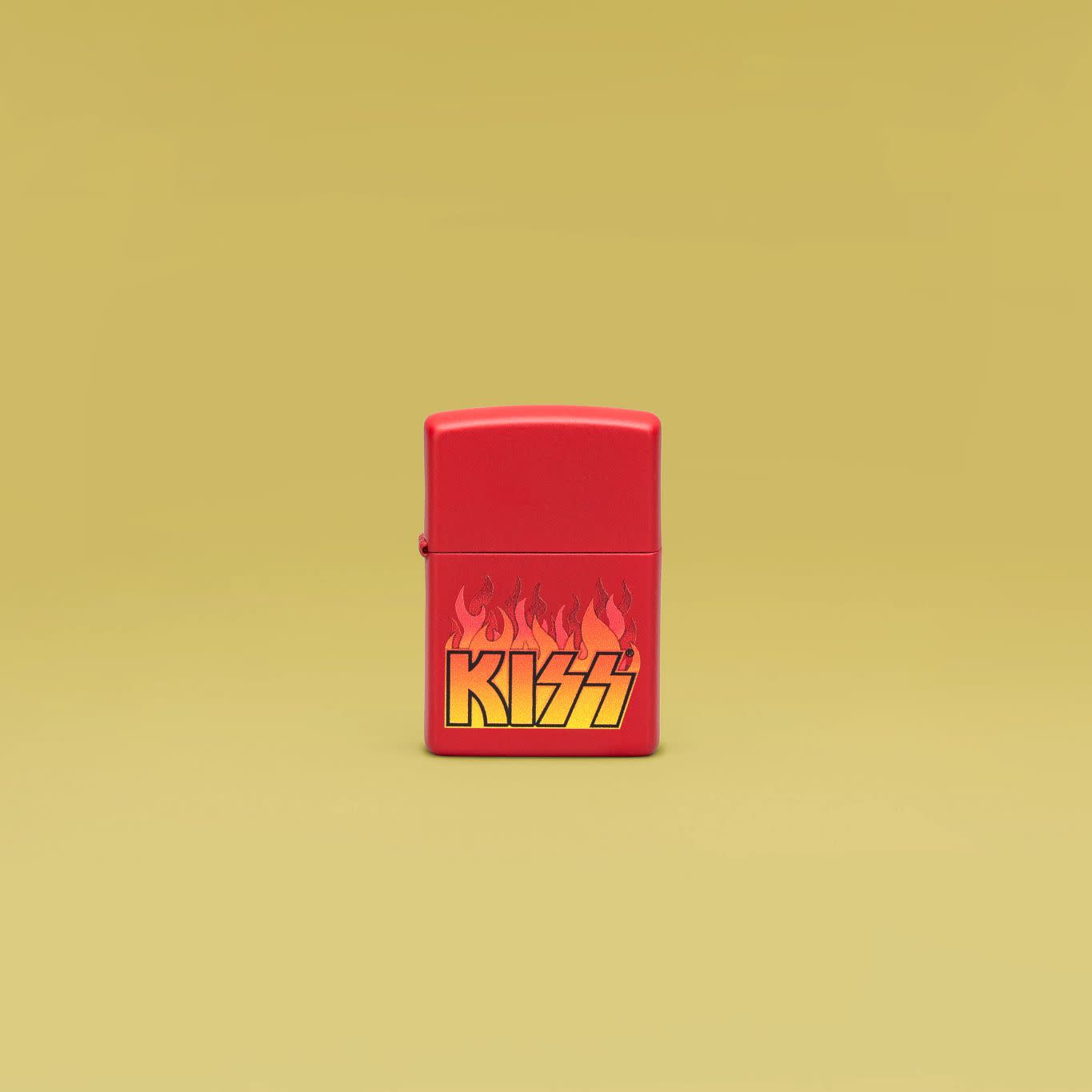 Lifestyle image of Zippo KISS Design Red Matte Windproof Lighter standing in a yellow scene.