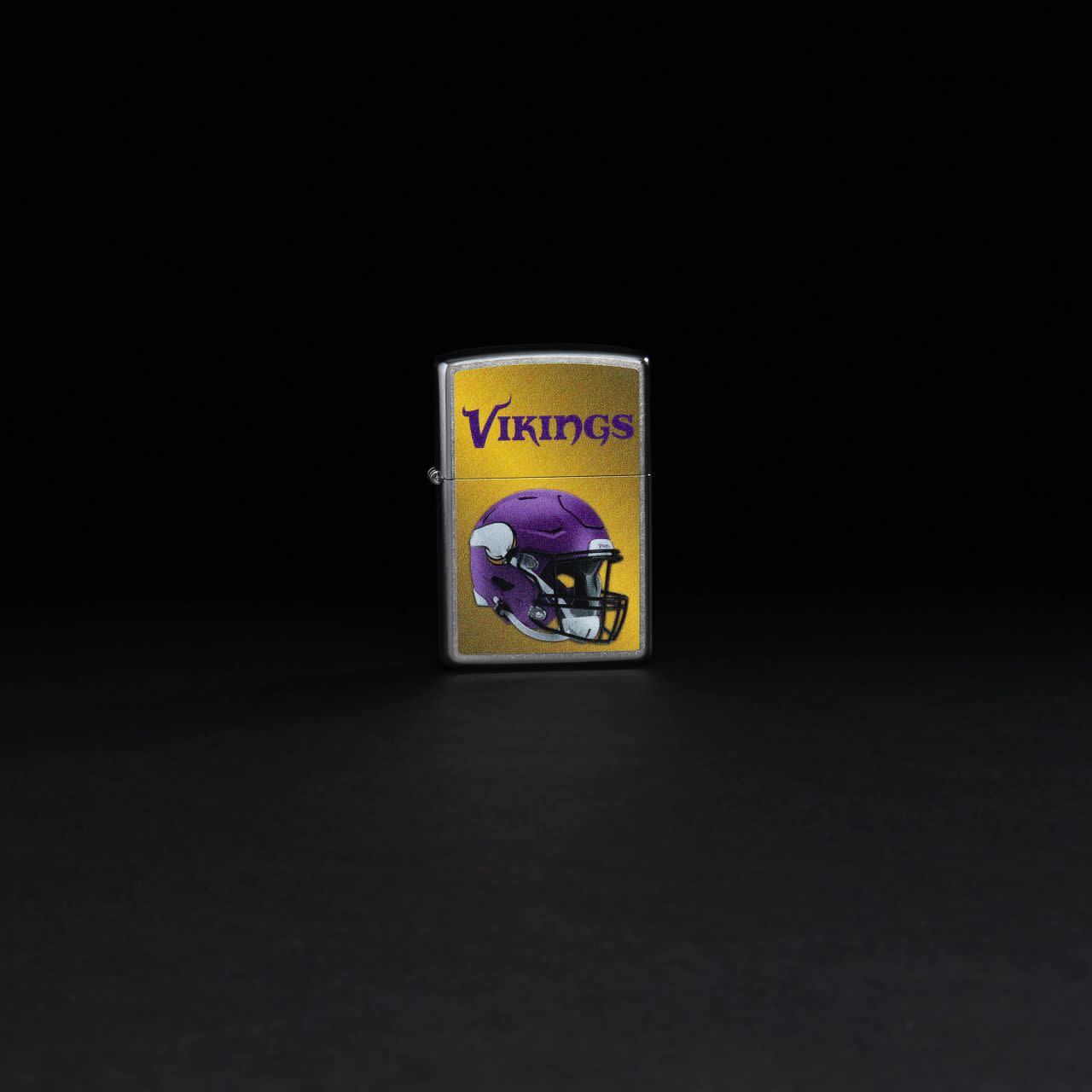 Lifestyle image of NFL Minnesota Vikings Helmet Street Chrome Windproof Lighter standing in a black background.