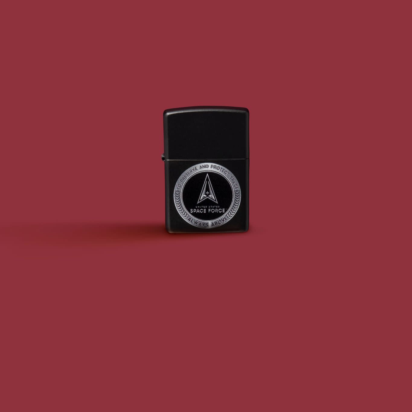 Glamour shot of Zippo U.S. Space Force Design Black Matte Windproof Lighter standing in a red scene.