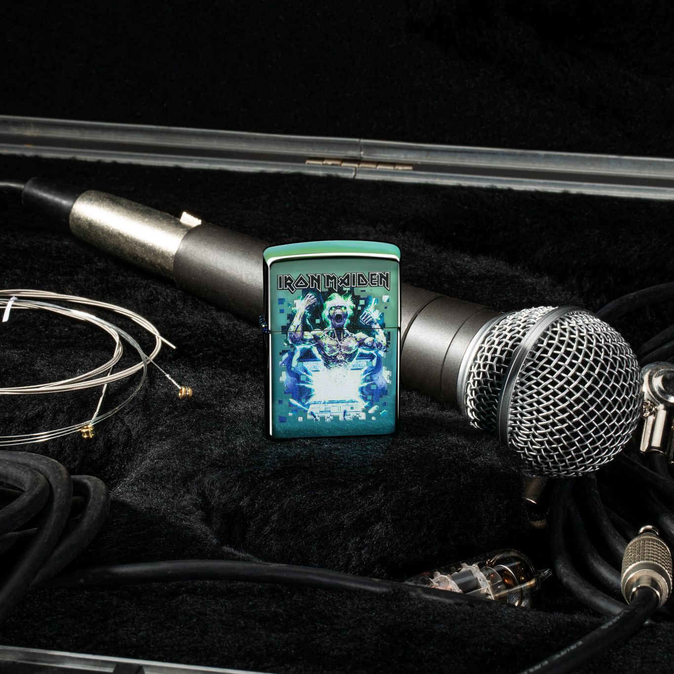 Lifestyle image of Iron Maiden Eddie Design High Polish Teal Windproof Lighter standing with a microphone behind it.