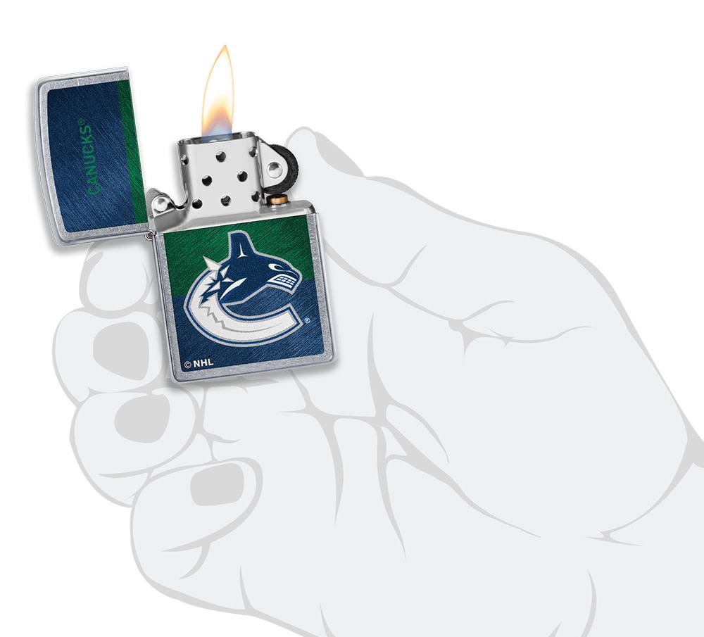 NHL® Vancouver Canucks Street Chrome™ Windproof Lighter lit in hand