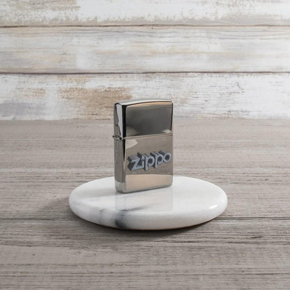 Lifestyle image of Zippo 3D Logo Design Black Ice® Windproof Lighter standing on a marble coaster.