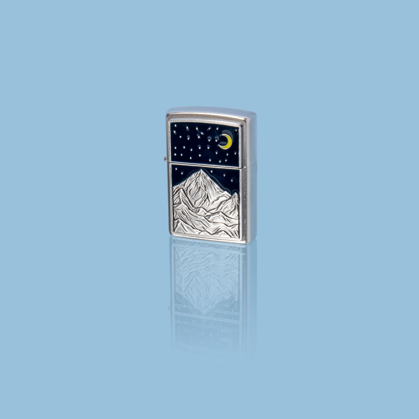 Glamour shot of Zippo Mountain Emblem Street Chrome Windproof Lighter standing in a blue scene.